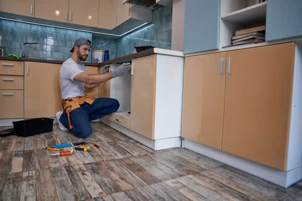 man installing kitchen cabinets