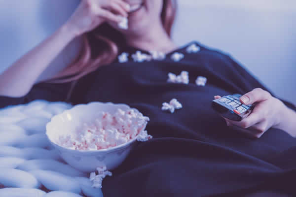 female sitting on chair eating popcorn