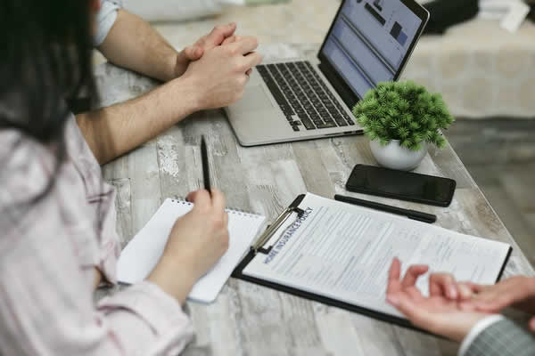 3 people with a laptop filling out a home insurance form