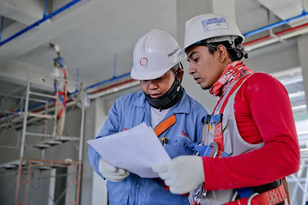 workman looking at building plans