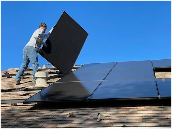 man installing solar panels on roof