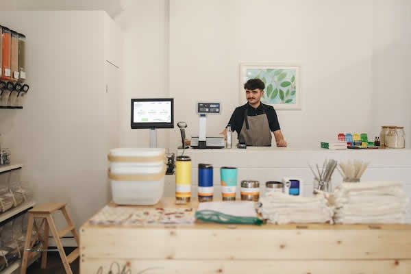 man standing behind counter of store