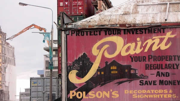 sign painted on the side of a building that says to paint
