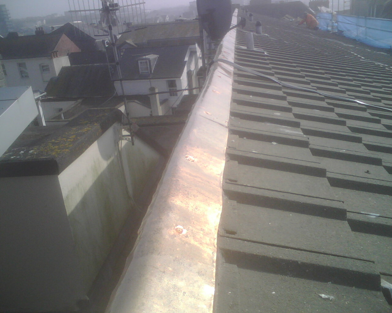 Image of the actual installation of a copper bar for moss control on a roof.
